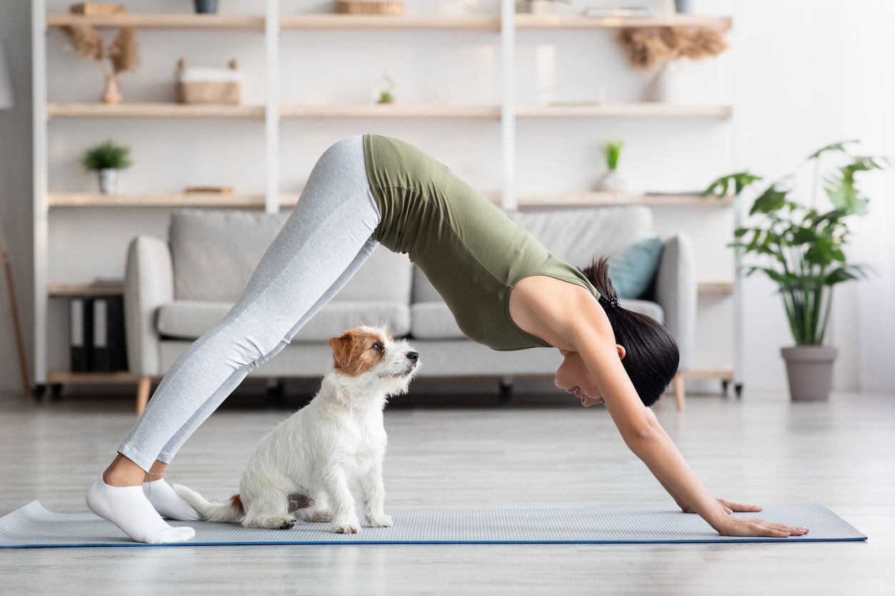 How to include your dog in your exercise routine - woman doing yoga with dog 
